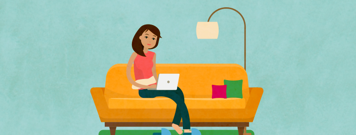 A woman sitting on a couch and working on her laptop