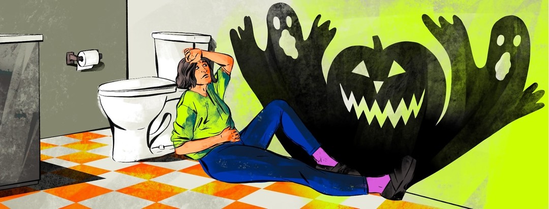 A woman looking sick and exhausted sits on the bathroom floor leaning against the toilet. A shadow of two ghosts and an evil jack-o-lantern is cast on the wall next to her.