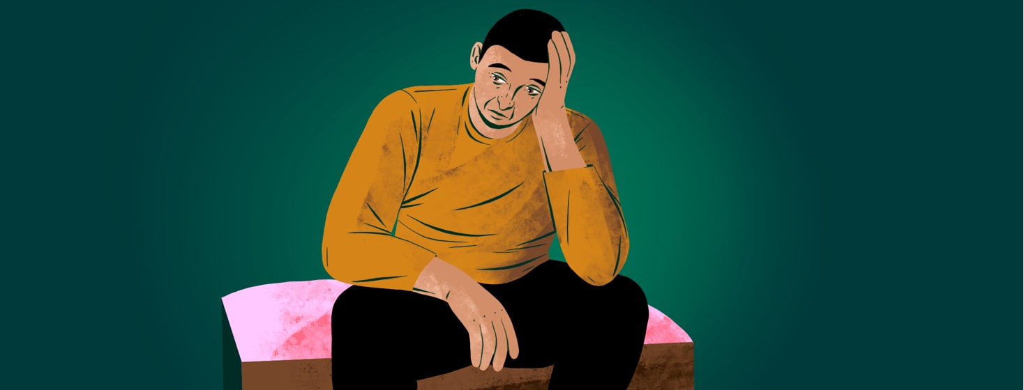 alt=A worried and exhausted man rests his head in his hand.