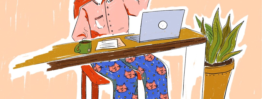 Person sitting at desk with a button up shirt on a cat themed pajama bottoms
