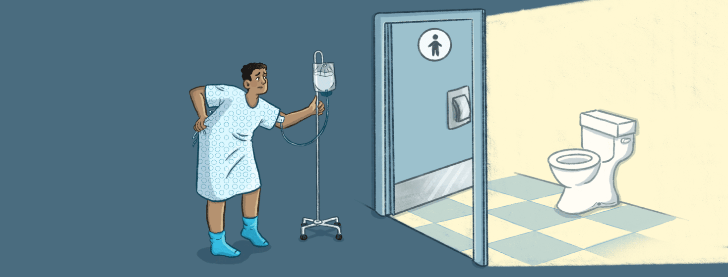 A man in a hospital gown walks toward the bathroom with his IV