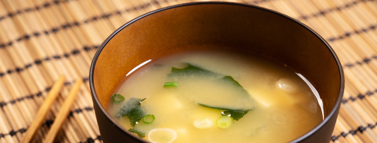 Miso soup on a table next to chopsticks
