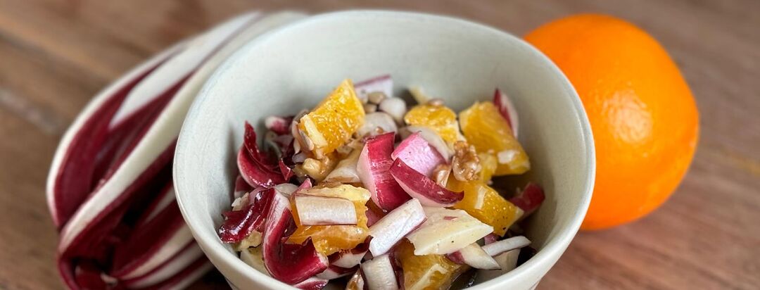 Image of Winter Citrus Salad with Radicchio and orange in the background