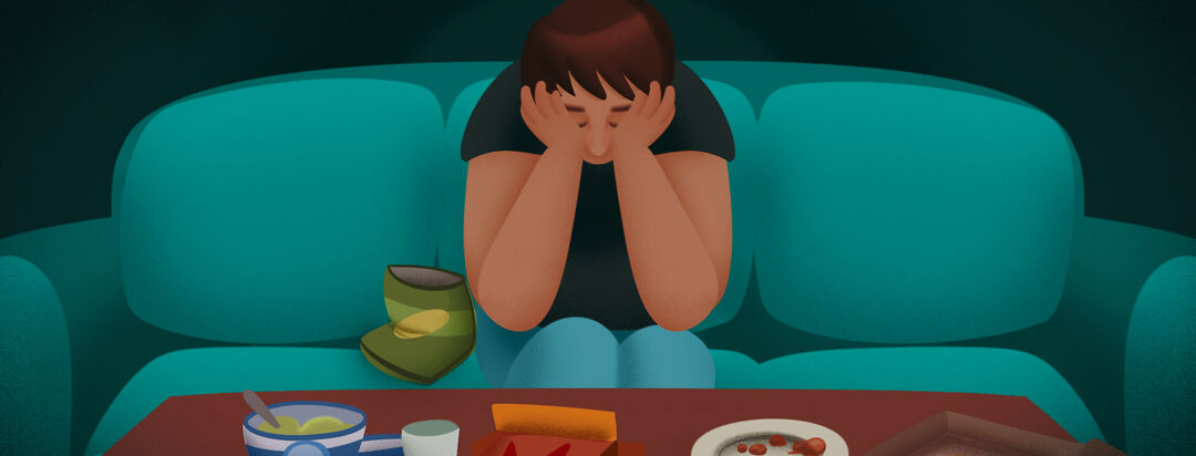A man sits looking defeated on the couch with his head in his hands, surrounding him are eaten through containers of food.